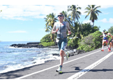 Warfel is shown running alongside the ocean in Hawai’i during the IRONMAN race.